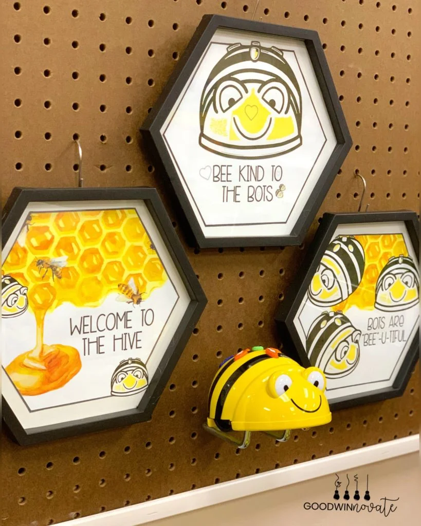 Picture of Beebot posters displayed on a classroom wall in hexagon shaped frames.